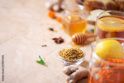 Autumn picnic. Herbal tea, honey and bee products, apple, lemon, calendula, spices on craft paper background. Immune system support with alternative medicine. Copy space