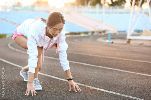 Sporty Asian woman in crouc...