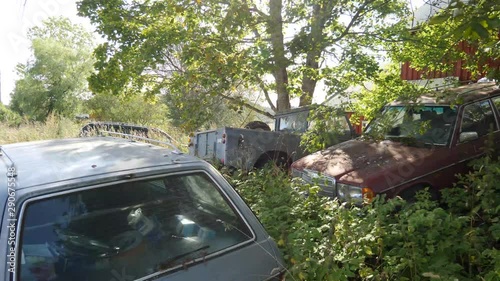 Old cars and trucks abandoned in a farmer's field - concept: forgotton, abandoned, broken, lost, disguarded, unloved 