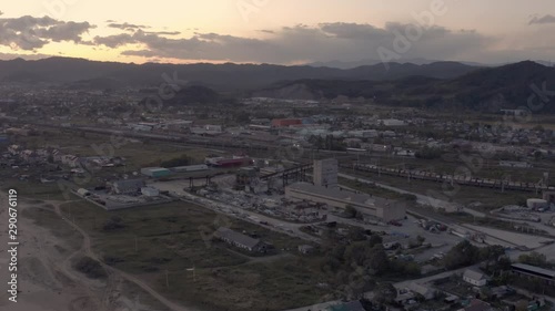 Concrete making factory industrial complex near seaside in the evening with town buildings in the background, Far East, Russia photo