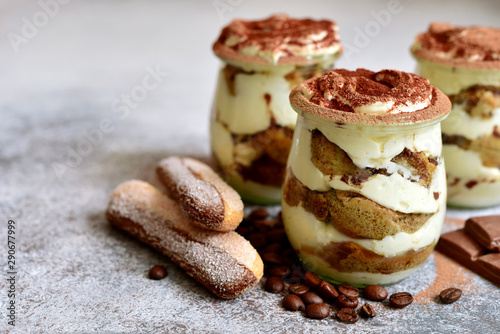 Traditional italian creamy dessert with mascarpone, biscuit and coffee in a vintage jars.