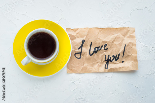 Yellow cup of coffee on a white background. Minimalism. Top view. I love you. Close up. Concept St. Valentine's Day