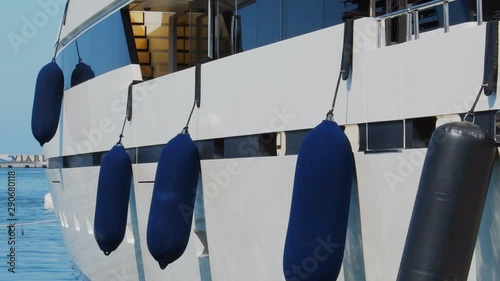 Many blue buoys hanging on the side of the boat in Viareggio in Italy - Real Time in 4K photo