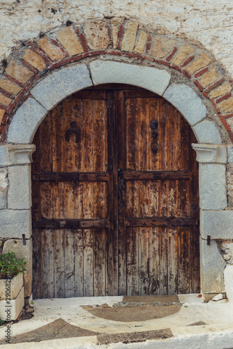 The background old, stone wall with wooden retro door