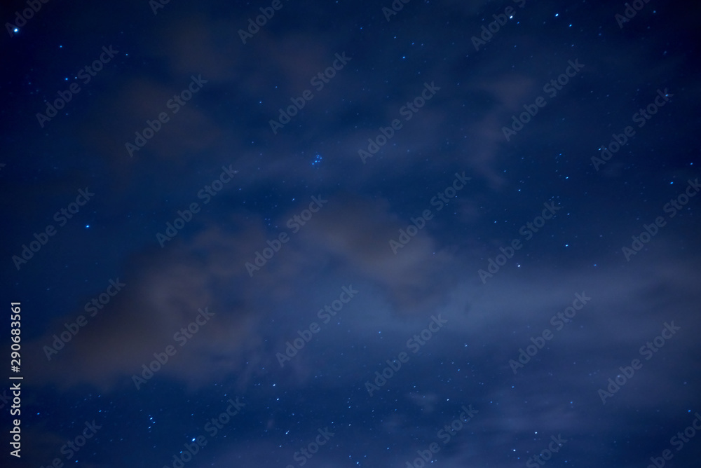 Night starry sky. Bright stars and constellations are visible through light clouds. Night starry sky. Bright stars and constellations are visible through light clouds.