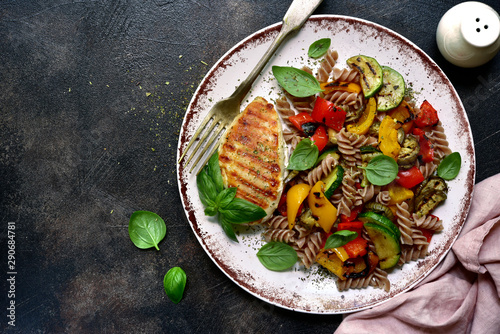 Whole grain pasta fusilli with grilled vegetables. Top view with copy space.