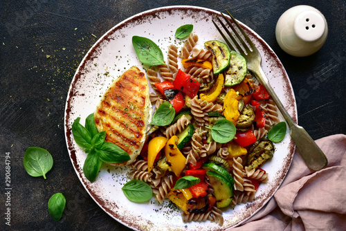Whole grain pasta fusilli with grilled vegetables. Top view with copy space.