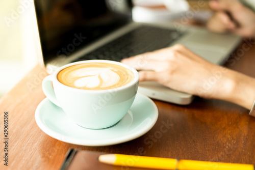 Coffee cup on wooden table and laptops notebooks.
