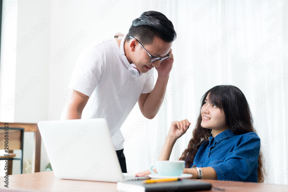 Young woman and man or student using laptop sitting at coffee shop. Happy girl working online or studying and using notebook. Freelance business concept. Young woman and man or student using laptop sitting at coffee shop. Happy girl working online or studying and using notebook. Freelance business concept.