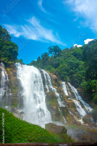 The the grand waterfall in the nature park with the greenery trees and forest in the nice day.