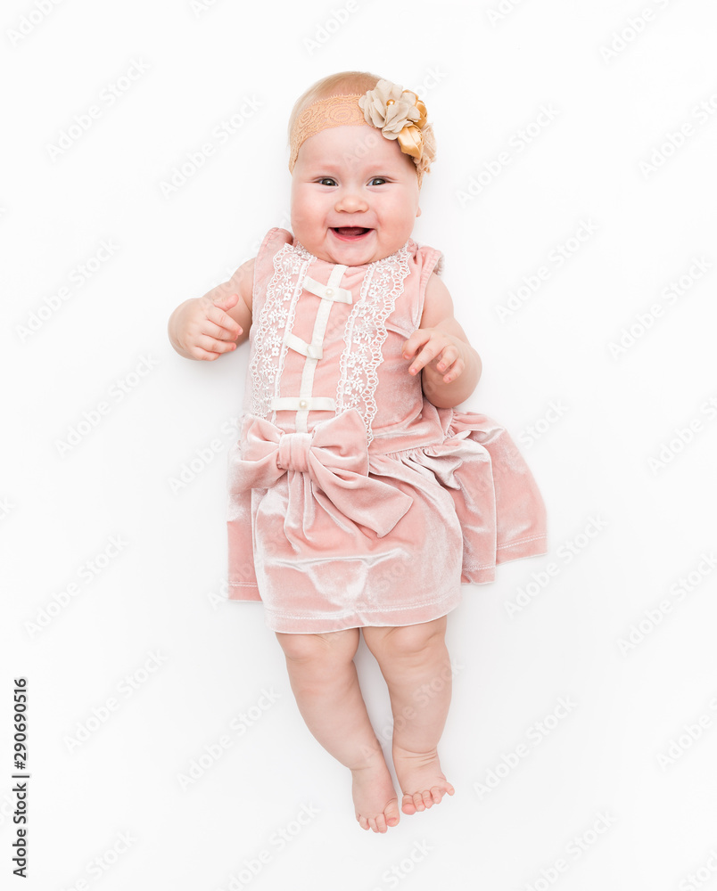 Portrait of a sweet infant wearing a pink dress, headband bow, isolated on white in studio. Portrait of a sweet infant wearing a pink dress, headband bow, isolated on white in studio.