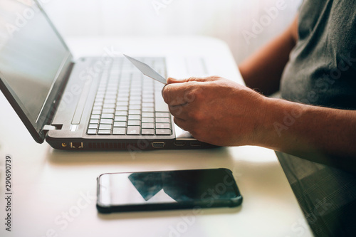 Old man shopping online with credit card. Older society adapting to news technologies.