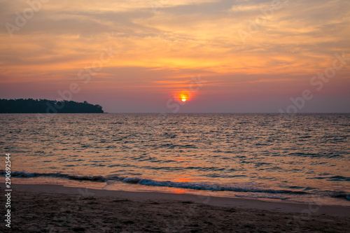 sunset on the sea. sandy beach  clear water  waves. surf line in the warm colors of the setting sun.