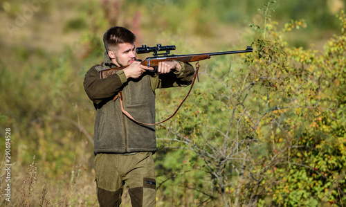 Hunter hold rifle. Hunting is brutal masculine hobby. Hunting and trapping seasons. Bearded serious hunter spend leisure hunting. Man brutal unshaved gamekeeper nature background. Hunting permit