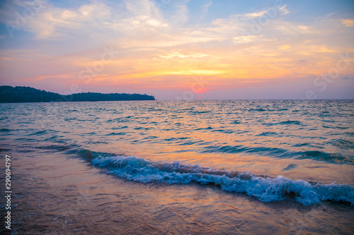 sunset on the sea. sandy beach, clear water, waves. surf line in the warm colors of the setting sun.
