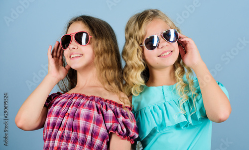 style only. happy small girls with long healthy hair. kid summer fashion. hairdresser salon. beauty and fashion. long blond curly hair. cheerful small girls in sunglasses. trendy sisters. friendship