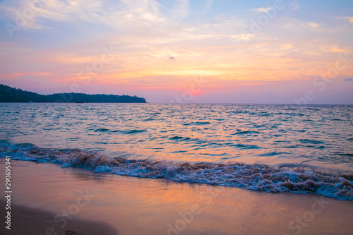 sunset on the sea. sandy beach, clear water, waves. surf line in the warm colors of the setting sun. © Alwih