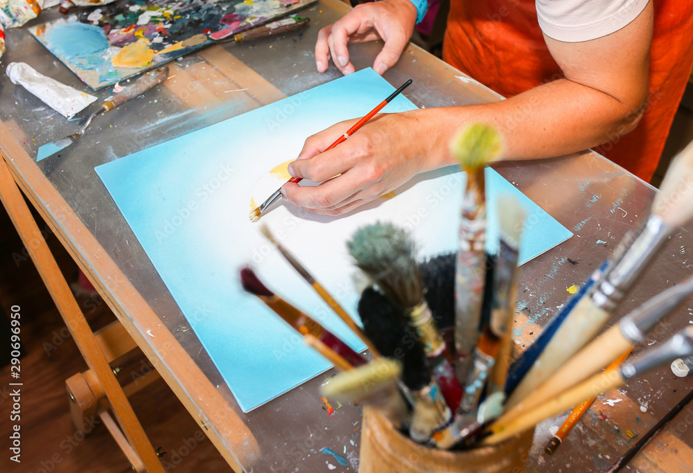 Fototapeta premium Real work studio of the painter. Man is creating picture. Artist concept. Creative atmosphere. Paint palette knife. Brushes.