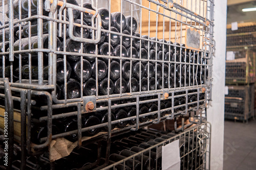 Many bottles are on racks at the winery.