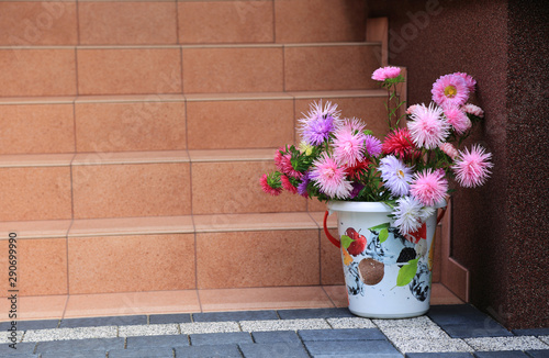 Piękna kolorowa dekoracja z kolorowych kwiatów i wiaderka na schodach domu.