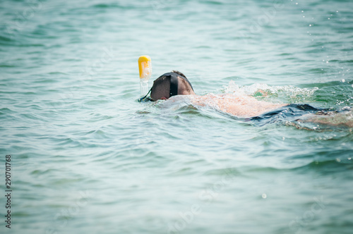 Man swimming with snorkeling mask in the ocean