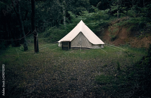 Big camp tent in white fabric in a forest