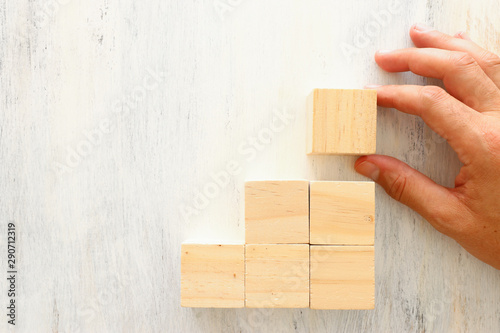 business concept of man hand arranging wooden blocks. mock up or template