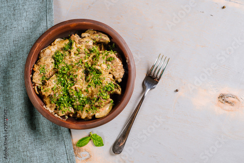 Dish of liver with herbs on the wooden background