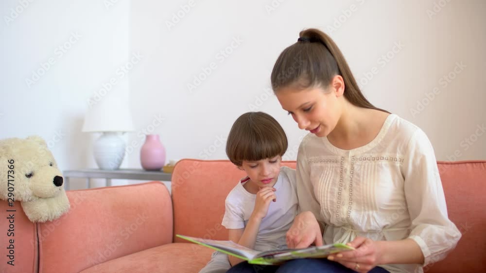 Mother and son reading books. Happy young mother and little boy child read books on sofa at home room. motherhood, home schooling. education, happy family 4 K Mother and son reading books. Happy young mother and little boy child read books on sofa at home room. motherhood, home schooling. education, happy family 4 K