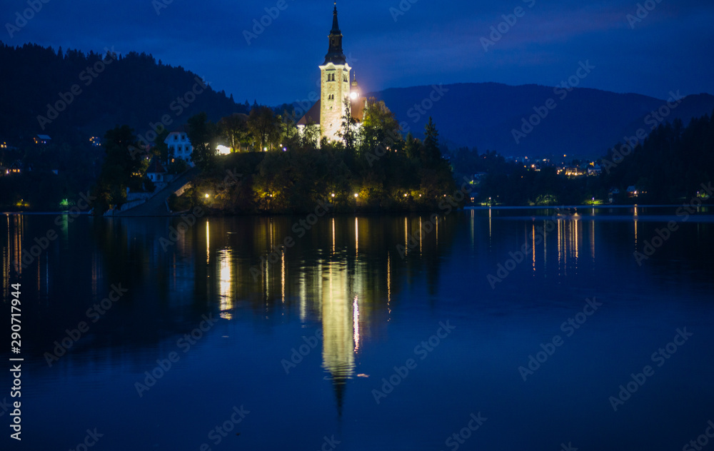 Sunset over the majestic Lake Bled in Slovenia with reflection of the church on the water 