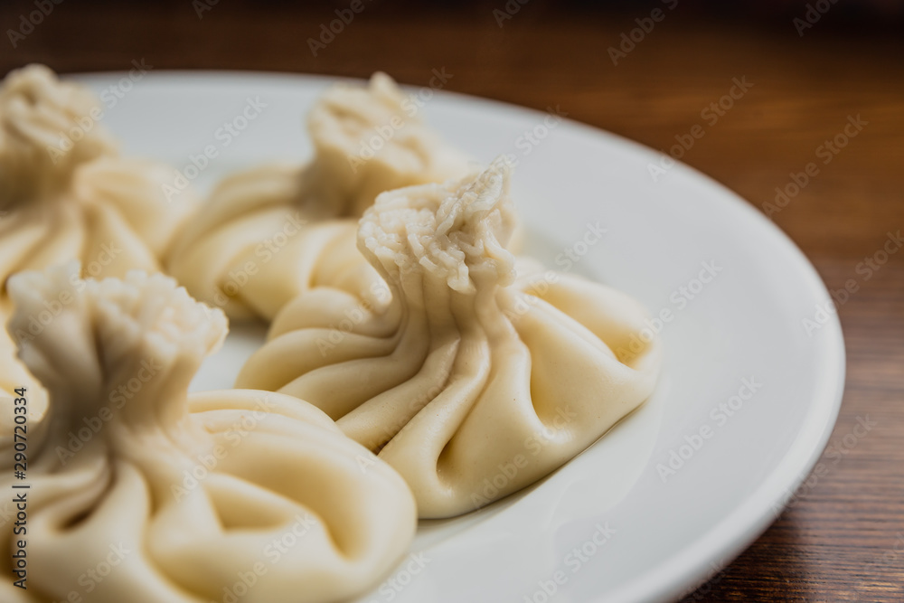 A horizontal photo of khinkali on a white plate.