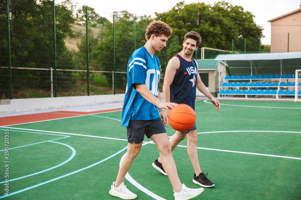Obraz premium Two smiling confident basketball players walking