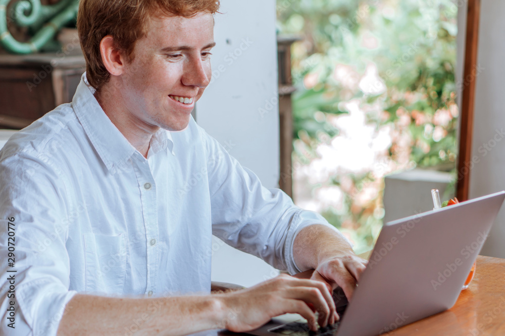 man typing on laptop looking at laptop and smiling man typing on laptop looking at laptop and smiling