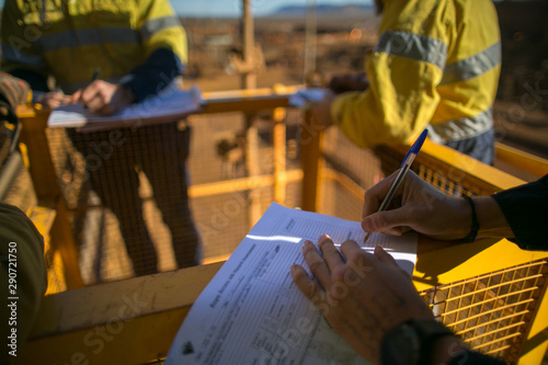 Rope access miner supervisor sigh of JSA risk assessment permit to work on site prior to performing high risk work on construction mine site, Perth, Australia 