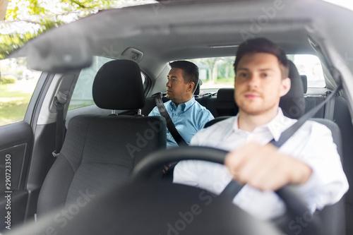 transportation, vehicle and people concept - middle aged male passenger on back seat and car driver