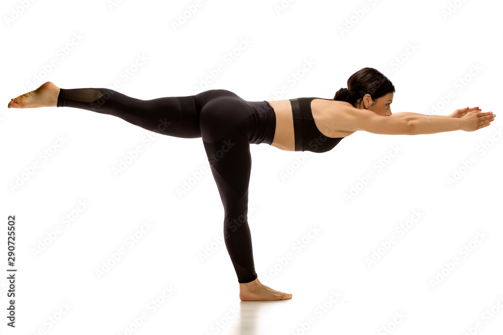 Young woman doing yoga warrior III pose. Isolated on white background.