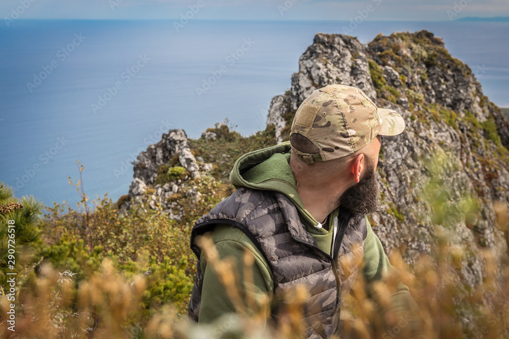 Naklejka premium Man in camo on mountain ridge 