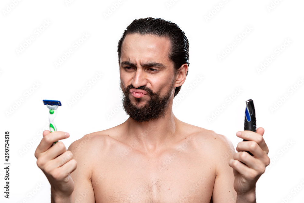 Bearded man with mustache chooses between electric razor and old ...