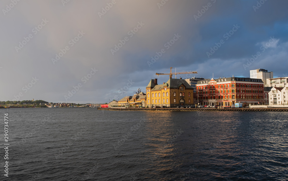 Stavanger, Norway - July 2019: The harbour in Stavanger city. This area is called Vågen. Evening with the rainbow