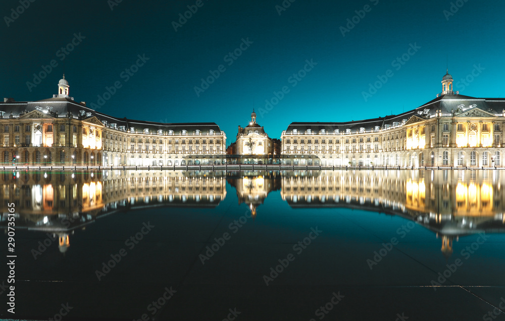 Place de la bourse with reflection in the water mirror and a tram passing by , 