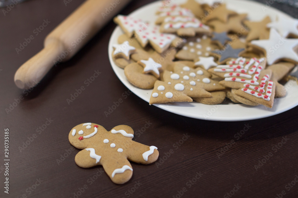 gingerbread cookies on a white plate on a dark brown wooden table gingerbread cookies on a white plate on a dark brown wooden table