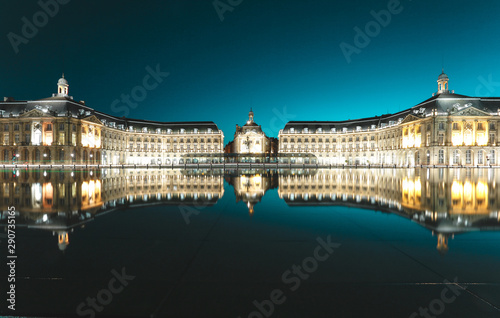 Place de la bourse with reflection in the water mirror and a tram passing by , 