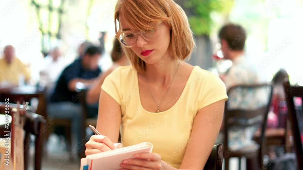Pretty woman making notes in cafe in the city, 4K Stock 비디오 | Adobe Stock