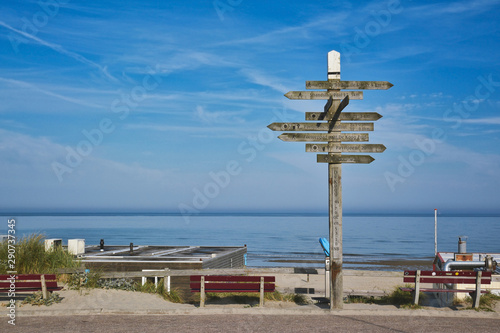  August 2019: Wooden signpost showing in multiple different directions at beach on island Texel
