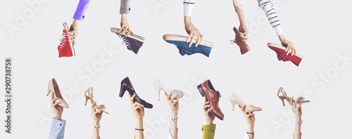 Hands holding different shoes on isolated background