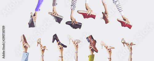 Hands holding different shoes on isolated background