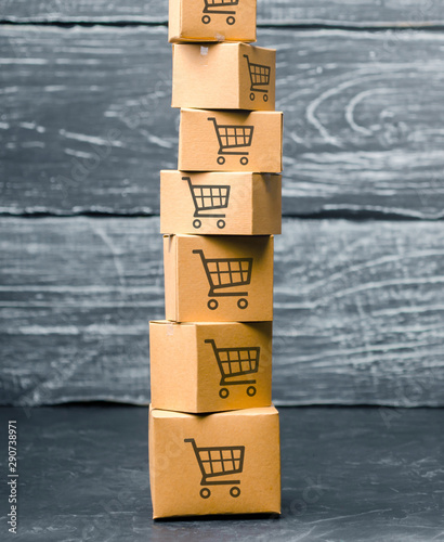 Tower of cardboard boxes with pattern of shopping carts on a blue background. commerce, online shopping. Purchasing power, delivery order. E-commerce, logistics, distribution and sales.