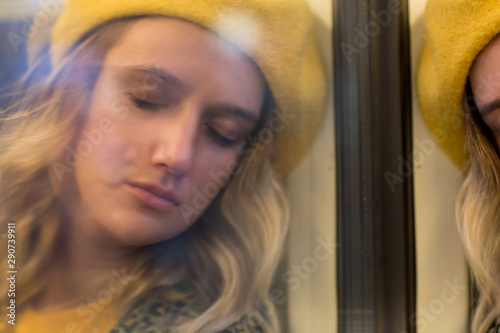 beautiful young woman in front of the window. Window reflection of a woman