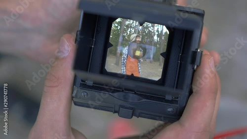 Small tiny camera screen with video of posing pretty young girl with cup of tea or coffee on the background of forest. Close-up