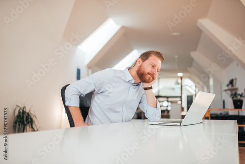 Wallpaper Mural Low angle image of positive businessman looking at laptop screen while sitting at the desk, copy space. Torontodigital.ca